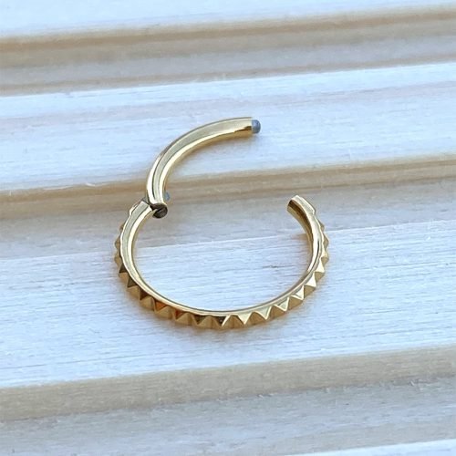 Alternative view of Aro clicker de titanio y baño de oro 24 Kt. con textura pirámide