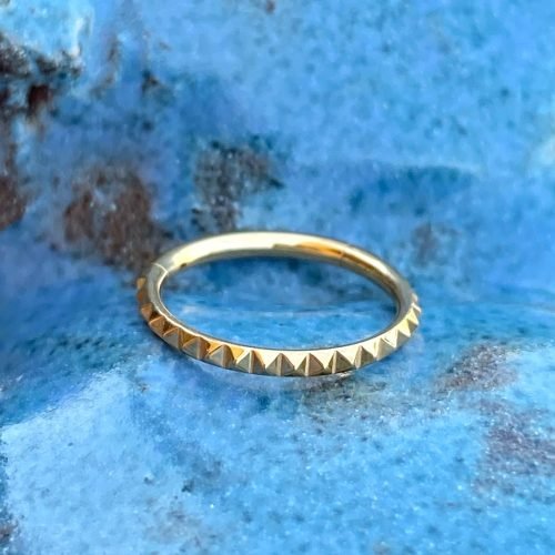 Aro clicker de titanio y baño de oro 24 Kt. con textura pirámide