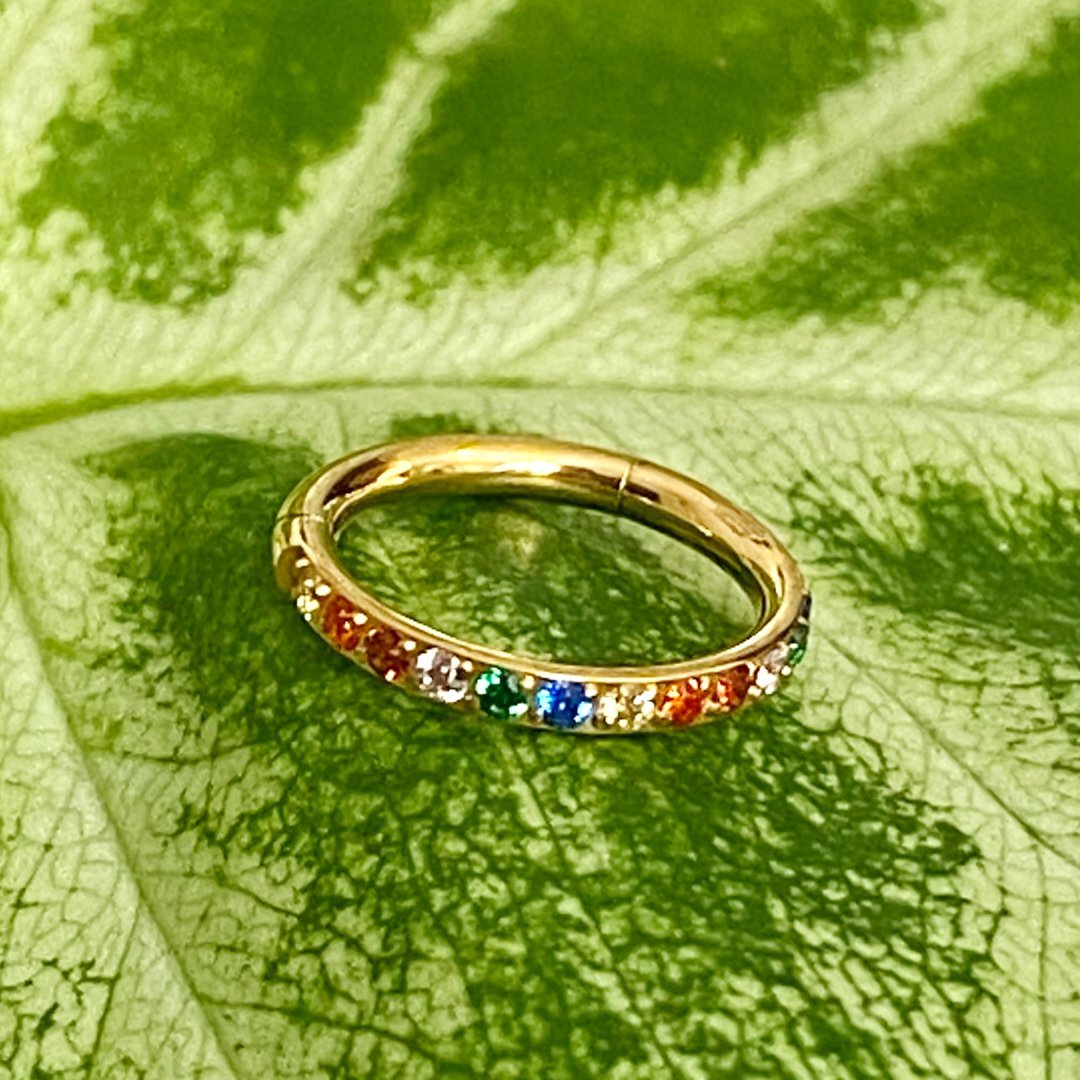 Aro clicker de titanio con baño de oro y zirconias multicolor