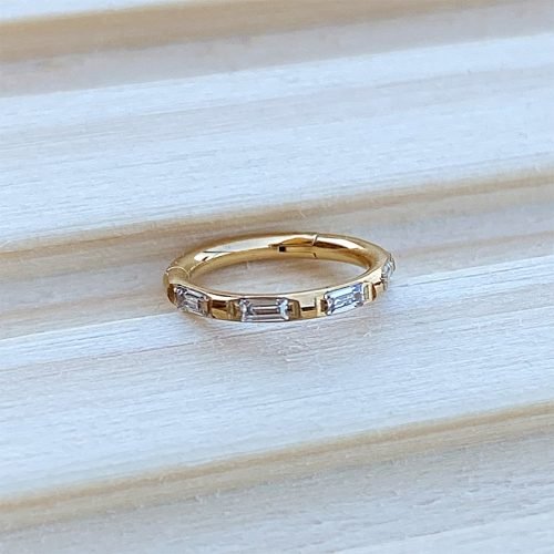 Aro clicker de titanio con baño de oro y zirconias talla baguette